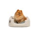 Ein flauschiger Pomeranian-Hund sitzt bequem in einem beigen Haustierbett mit einem weichen grauen Innenraum.