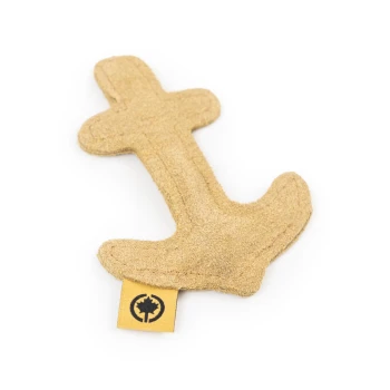 Ein tanfarbener, plüschiger Anker-förmiger Hundespielzeug mit einem kleinen gelben Etikett, das ein Baum-Logo zeigt.