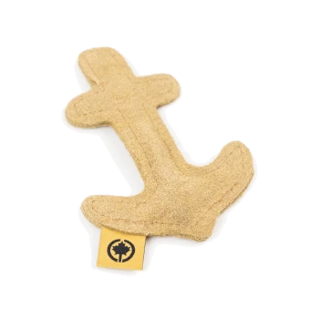 Ein tanfarbener, plüschiger Anker-förmiger Hundespielzeug mit einem kleinen gelben Etikett, das ein Baum-Logo zeigt.