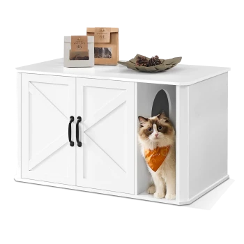 Eine flauschige Katze mit blauen Augen in einem orangefarbenen Halstuch schaut aus einer weißen Haustier-Einheit mit schwarzen Türen, die mit Leckerlitaschen und Tannenzapfen bedeckt ist.