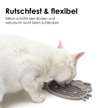 Der Rücken einer Katze ist im Vordergrund zu sehen, die auf drei farbenfrohe, silikonartige Futtermatten in Form von Hello Kitty auf einer Holzoberfläche schaut.