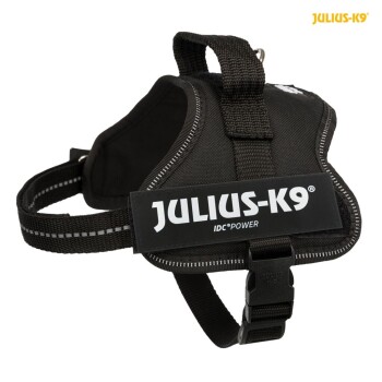 Schwarzes Hundegeschirr mit dem Etikett 'JULIUS-K9 IDC®POWER', mit verstellbaren Riemen und einem stabilen Griff oben.