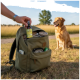 Hand steckt eine Flasche mit der Aufschrift 'Grasmilben' in einen olivgrünen Rucksack mit Tierbedarf; ein goldener Hund sitzt in der Nähe.