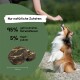Ein glücklicher Hund, der einen Trick für einen Leckerbissen vorführt, mit einer Nahaufnahme von natürlichen Hundesnacks, die mit "95% getrocknetes Rotwildfleisch, 5% Hanfpulver" beschriftet sind.