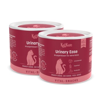 Zwei Dosen KatKare Urinary Ease Katzensnacks mit pinkem Etikett, das eine Katzenillustration und Text zu Antioxidantien, Superfood und Postbiotika zeigt.