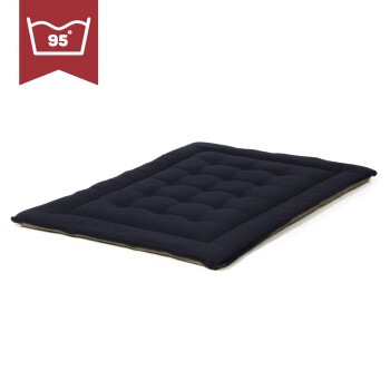 Ein dunkelblaues Haustierbett mit einem gepolsterten Design, mit einem Etikett, das angibt, dass es bei 95°F maschinenwaschbar ist.