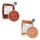 Verpackungen mit rohem Haustierfutter, gekennzeichnet mit 'Geflügelinnereien-Mix' und 'Weißler-Rinderpansen-Mix' mit Nährwertangaben, präsentiert mit Schalen voller Fleisch.