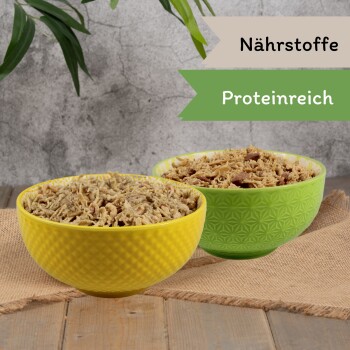 Premium-Hundefutter in einer Edelstahlschüssel, mit zerkleinertem Huhn und Ente, beschriftet mit "Huhn mit Ente."