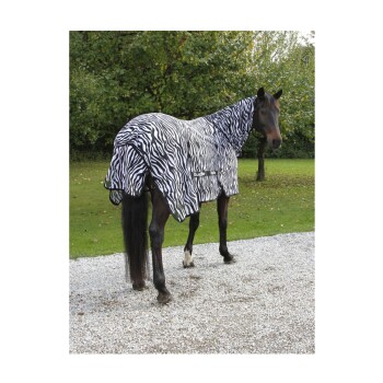 Ein Pferd, das eine schwarz-weiße, zebra-gestreifte Decke trägt, steht auf Kies, umgeben von grünen Bäumen.