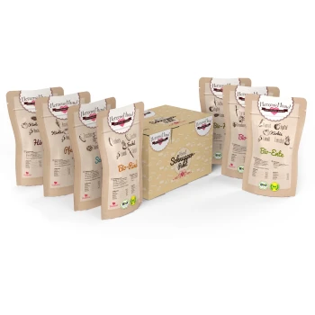 Adult Schnupperpaket Bio 7x130g Mixpaket Verschiedene Haustierfutterverpackungen von Herzen's Hund, einschließlich Bio-Rind und Bio-Ente, um eine zentrale "Schnupper-Paket"-Box angeordnet.