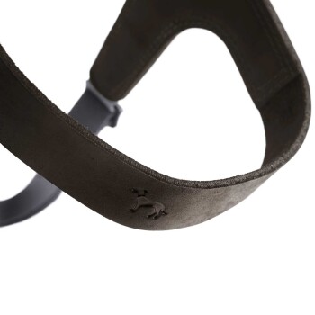 Nahaufnahme eines dunkelgrünen Hundegeschirrs mit einem subtil geprägten Hundelogo, das sein weiches Material und den verstellbaren Riemen zeigt.