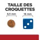 Comparaison de la taille des croquettes : 8,5 mm montrée par une croquette et 16 mm montrée par un dé bleu avec trois points.