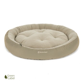 Runder, plüschiger Haustierbett in neutralem Beige mit gepolstertem Design, mit dem Logo "Doctor Bark" und einem "Green Label"-Symbol.