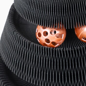 Nahaufnahme von zwei orangefarbenen Haustierbällen, die in einem schwarzen, strukturierten Haustierspielzeug liegen, das ein einzigartiges Design für interaktives Spielen zeigt.