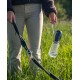 Eine Person, die in einer Hand eine Hundeleine und in der anderen eine tragbare Wasserflasche hält, steht auf einem grasbewachsenen Feld.