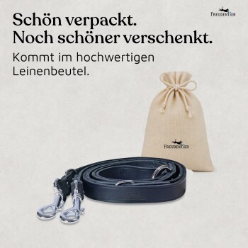 Schwarze Leder-Hundeleine mit Metallverschlüssen und beigem Leinensäckchen mit Kordelzug, Text auf Deutsch über Verpackung und Geschenkverpackung.