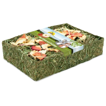 Une boîte rectangulaire remplie de morceaux de fruits secs et de foin, surmontée d'une étiquette colorée avec des animaux et le texte "Mini-Snack mit Früchten."