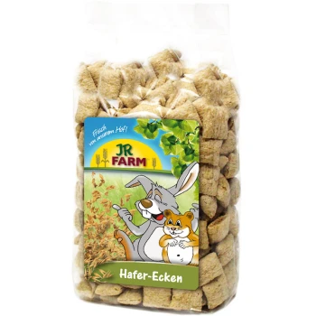 A clear bag of square oat treats for pets, with a colorful label featuring a cartoon rabbit and hamster, labeled "JR FARM Hafer-Ecken."