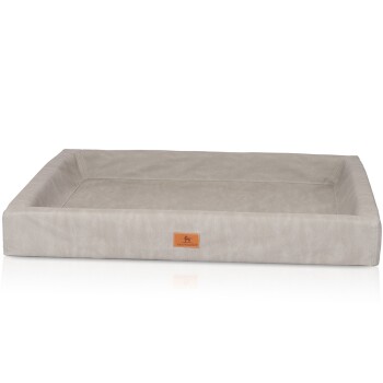 Ein hellgraues, rechteckiges Hundebett mit erhöhten Kanten und einer lederähnlichen Textur, das ein kleines braunes Etikett mit dem Markennamen "KNUFFERWUFF" trägt.