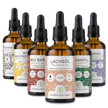 Sechs bernsteinfarbene Glasflaschen mit organischen Haustierölen, beschriftet mit Vorteilen für Hunde und Katzen, von "wolfsbacher natur."