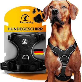 Schwarzes Hundegeschirr auf einer Verpackung mit dem Text "Tierhood HUNDEGESCHIRR" und einer deutschen Flagge, neben einem Hund, der das Geschirr trägt.