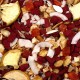 Een kleurrijke mix van huisdiervoeding met rode en bruine brokjes, gedroogde appelschijfjes, kokosvlokken en oranje en gele fruitstukjes.