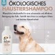 Ein glücklicher Golden Retriever in einer Badewanne mit Seifenblasen, neben einer Flasche ökologischen Haustiershampoos mit der Aufschrift "HAUSTIER PFLEGE SHAMPOO."