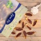 Eine teilweise geöffnete Tüte Lyra Nature Power Haustier-Leckerlis, mit mehreren Leckerlis in Form von Fischfilets, die auf einer Holzoberfläche verstreut sind.