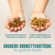 Zwei Hände halten Hundefutter: links mit Standardstücken, rechts mit größeren Stücke. Der Text lautet "Größere Krokettenstücke für größere Hunde."