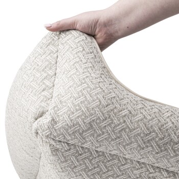 Eine Hand, die ein plüschiges, strukturiertes Haustierbett mit einem hellbeigen gewebten Stoff hält, das seine Weichheit und seinen Komfort zeigt.