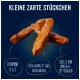 Hundeleckerlis auf einem dunklen Hintergrund, mit Text über Vitamine D & E, vollständige Ernährung und Omega-6-Fettsäuren.