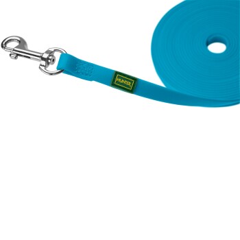 Blaue Hundeleine mit einem Metallclip und einem grünen "HUNTER"-Logoschild, im Hintergrund aufgerollt.