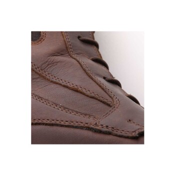 Nahaufnahme eines braunen Lederschuhs, der detaillierte Nähte und Schnürungen zeigt, mit einer strukturierten Oberfläche.