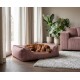 Brauner Hund schläft in einem rosa Cord-Hundebett mit Lederpatch mit der Aufschrift „KNUFFELWUFF“ in einem gemütlichen Wohnzimmer.