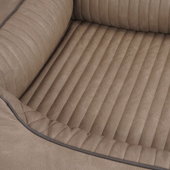 Eine Nahaufnahme eines plüschigen, beigen Haustierbettes mit einem gerippten Design und gepolsterten Seiten, ideal für den Komfort von Haustieren.