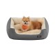 Ein flauschiger Pomeranian-Hund mit einem orangefarbenen Halstuch entspannt sich in einem gemütlichen grauen Haustierbett mit einem weichen cremefarbenen Innenraum.