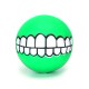 Grüner Gummiball mit einem cartoonhaften weißen grinsenden Design, ideal für die Spielzeit mit Haustieren.