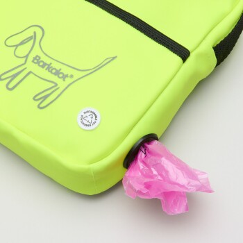 Heller gelber Abfallbeutelspender für Haustiere mit einem Hundelogo, mit einem teilweise herausgezogenen rosa Beutel.