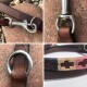 Nahaufnahmen eines braunen Leder-Hundeleinen mit Metallclips und Ringen, die detaillierte Handwerkskunst und Design zeigen.