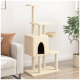 Ein beiger Katzenbaum mit mehreren Ebenen, einem gemütlichen Versteck und einer Schüssel, positioniert neben einem hellgrauen Sofa und einer Topfpflanze.