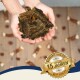 Eine Person hält einen großen natürlichen Tier-Leckerbissen zwischen kleineren knochenförmigen Leckerbissen auf Holz, mit einem Abzeichen, das "Bewährte Qualität seit über 15 Jahren" liest.