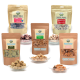 Verschiedene gefriergetrocknete Haustiersnacks in verschiedenen Verpackungen, darunter Lammlungen, Hühnerherzen und Insektenleckereien, auf Tellern präsentiert.
