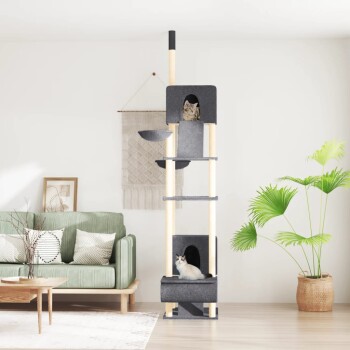 Ein dunkelgrauer Kratzbaum mit zwei Katzen, die auf verschiedenen Ebenen in einem stilvollen Wohnzimmer mit einem grünen Sofa und einer Topfpflanze ruhen.