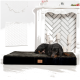 Ein schwarzer und brauner Hund ruht auf einem plüschigen Haustierbett in einem stilvollen Raum mit einem weißen Kamin und Kerzen, mit einem Logo auf dem Bett.