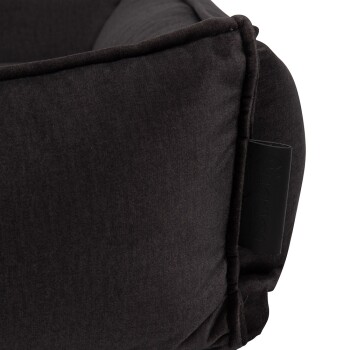 Eine Nahaufnahme eines dunkelgrauen Haustierbettes mit einem strukturierten Stoff und einem kleinen schwarzen Etikett an der Seite.