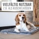 Ein Beagle, der auf einer weichen, grauen Tiermatte in einem modernen Innenraum liegt. Der Text darüber lautet "Vielfältig nutzbar z.B. als Kuschelkissen."