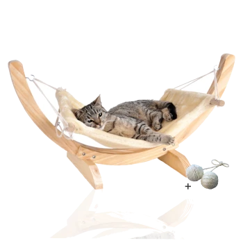 Eine entspannte getigerte Katze, die auf einer hölzernen Hängematte mit einem weichen, cremefarbenen Stoff liegt. Zwei Spielbälle sind im Bild enthalten.