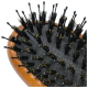 A close-up of a pet grooming brush with a wooden handle, featuring densely packed black bristles and rounded tips for gentle grooming.