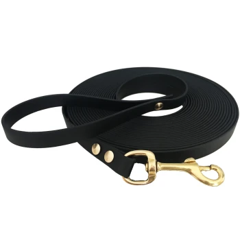 15-25 kg Biothane Schleppleine schwarz 10 m Schwarze Gummihundeleine, aufgerollt mit einem goldenen Metallverschluss und dekorativen Nieten, vor einem weißen Hintergrund.