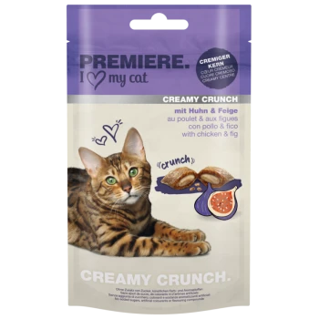 A Bengal cat rests next to a "Premiere I Love My Cat" Creamy Crunch treats package, showcasing chicken and fig flavor.